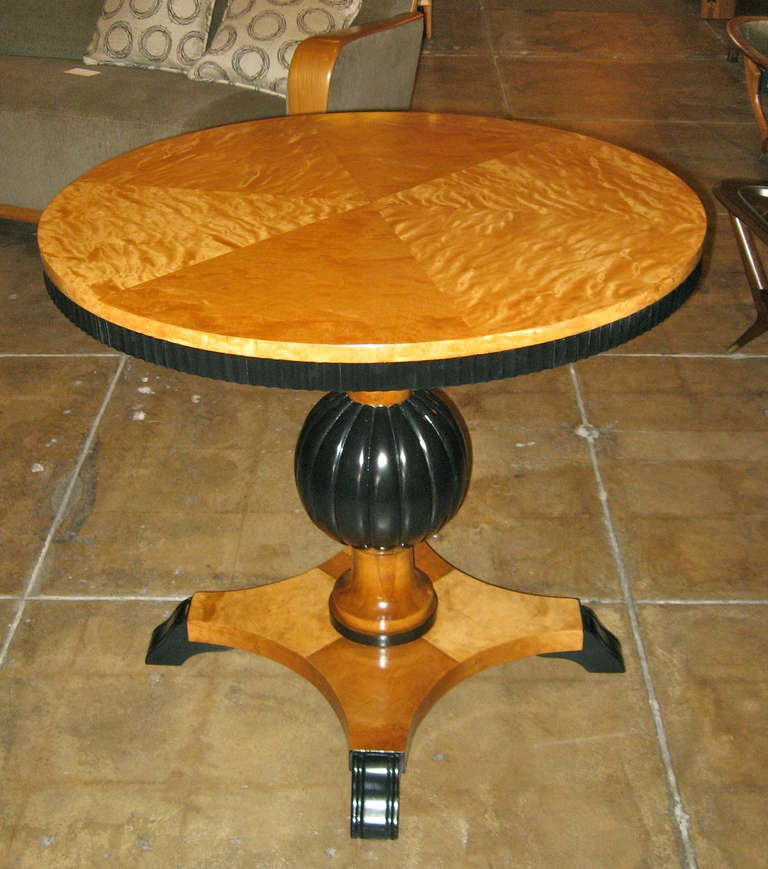 Swedish art deco/Biedermeier revival game table rendered in highly figured golden flame birch with ebonized birch detail. Ebonized birch ball column. Book matched birch top. In excellent restored condition. Crafted in Sweden ca. 1930.