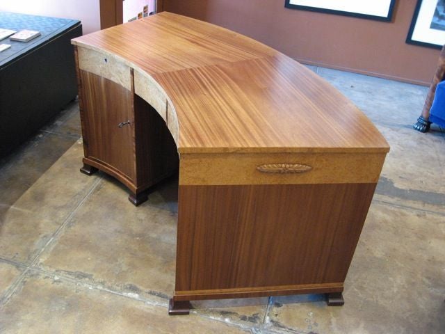 Swedish art deco curved desk with build in book case. Woods include karelian birch, mahogany and rosewood. Three drawers in front in karelian birch. Back is mahogany with removable adjustable exposed book shelves. Designed at Svenska Mobelfabriken