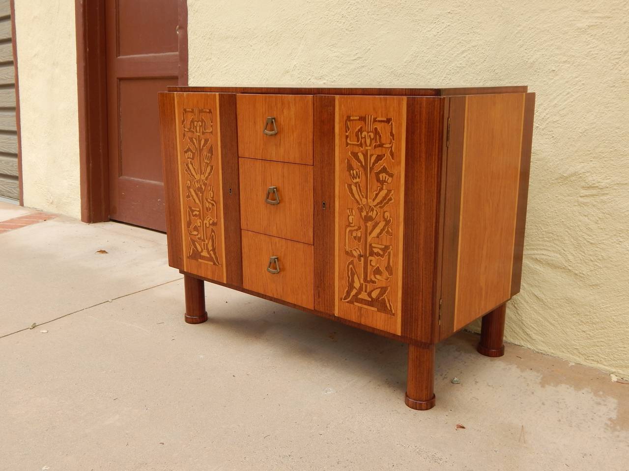Swedish Art Deco era inlaid dresser, cabinet or hall piece by Erik Chambert.
Composed of rosewood, elm, flame birch and pear wood. Interior composed of storage cabinets with removable shelves and three drawers with original bronze pulls. Made at