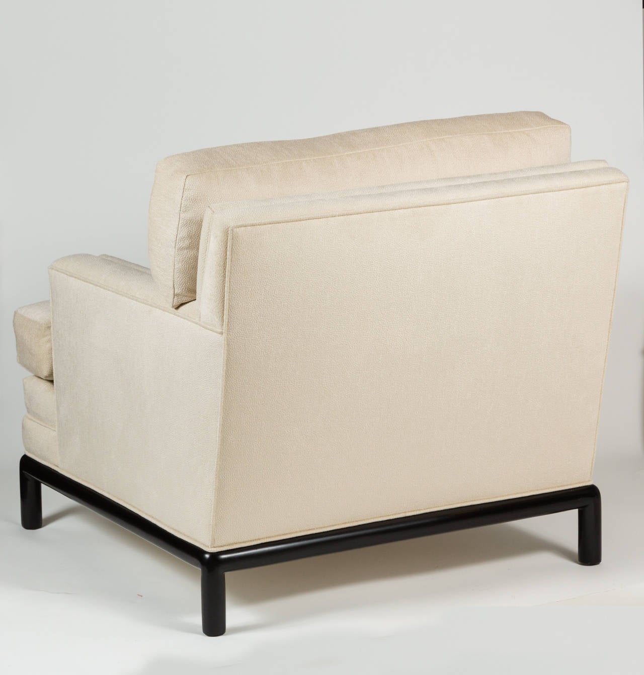 Elegant pair of armchairs with ebony lacquered wood bases and new upholstery in a cream, textured fabric. Graceful lines contribute to the desirable and welcoming design. Cushions have a feather/ down content, giving them a luxurious feel.