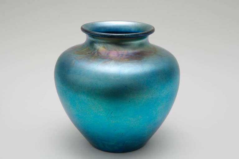 A beautiful and vibrant blue Aurene vase, designed by Frederick Carder, one of the co-founders of Steuben Glass. Aurene glass was one of his earliest color effects created for Steuben Glass, and the blue was produced from 1904 through the mid 1920s.