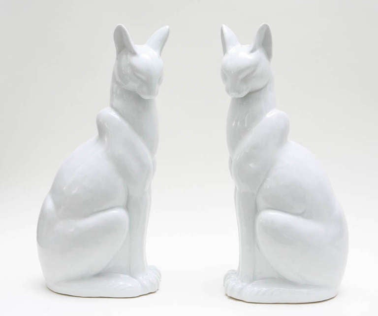 A regal pair of white glazed ceramic Abyssinian cats. Marked on the underside with Japanese characters, one of the cats also retains a paper 