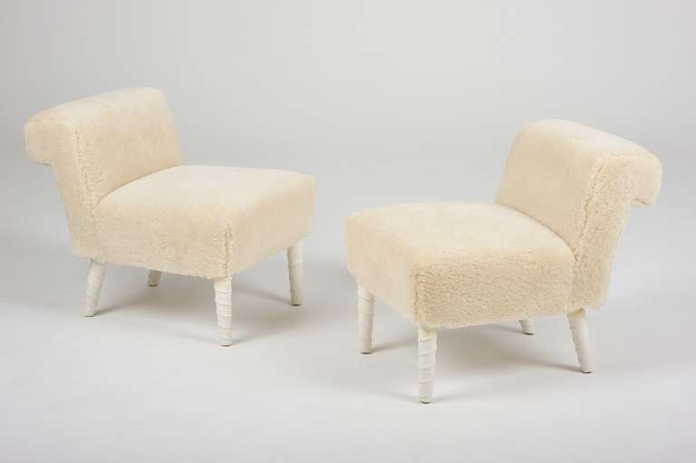 A chic pair of white leather wrapped unicorn leg shearling upholstered elbow chairs by William Haines from the estate of American composer, songwriter, conductor and playwright, Meredith Willson, best known for creating Broadway's 