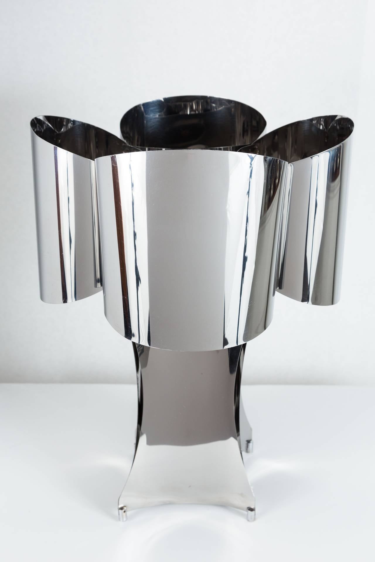 Attractive polished stainless steel table lamp with four standard European sockets (require adaptors for US bulbs), surrounded by gracefully shaped stainless 