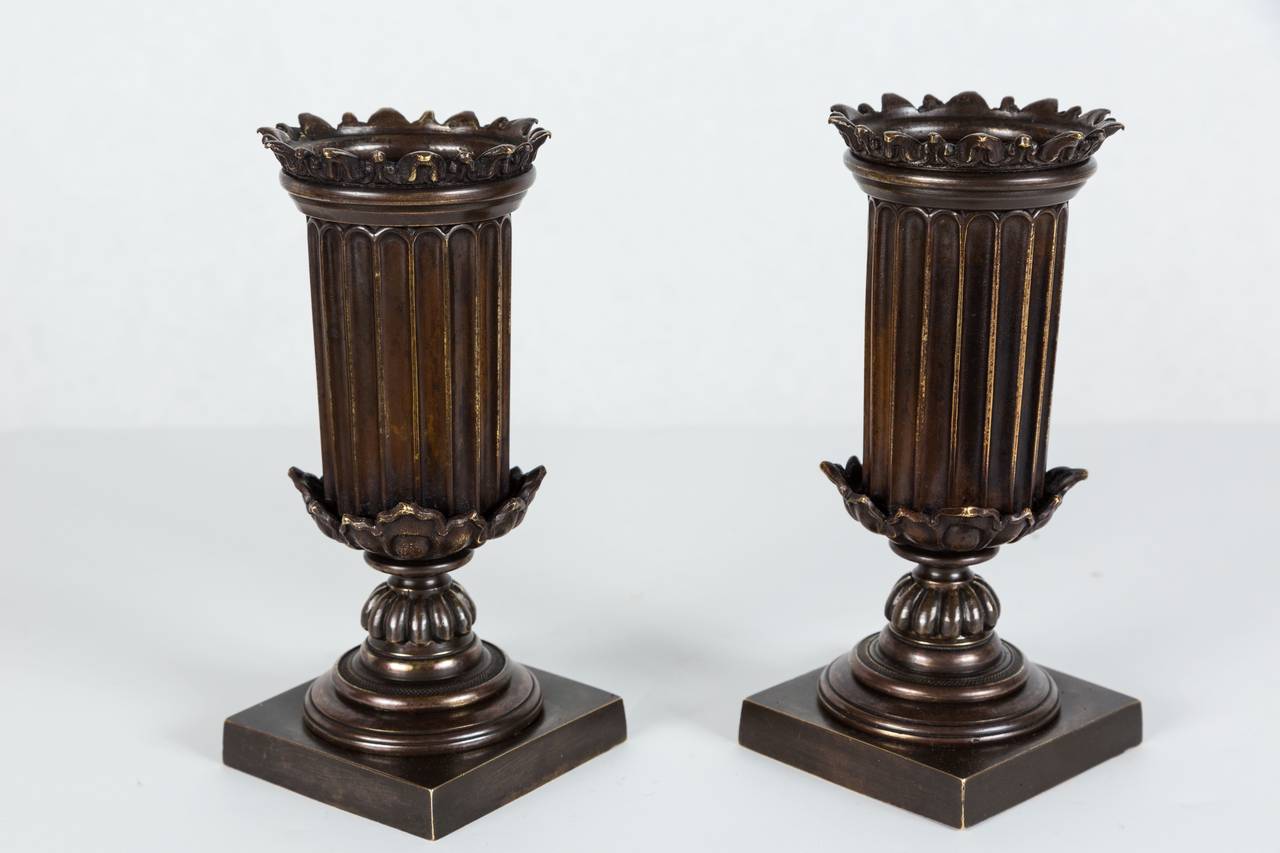 Decorative pair of bronze column vases with weighted (internal) iron bases. Vases have a rich patina and lovely neoclassical details. 

Overall Dimensions: 7