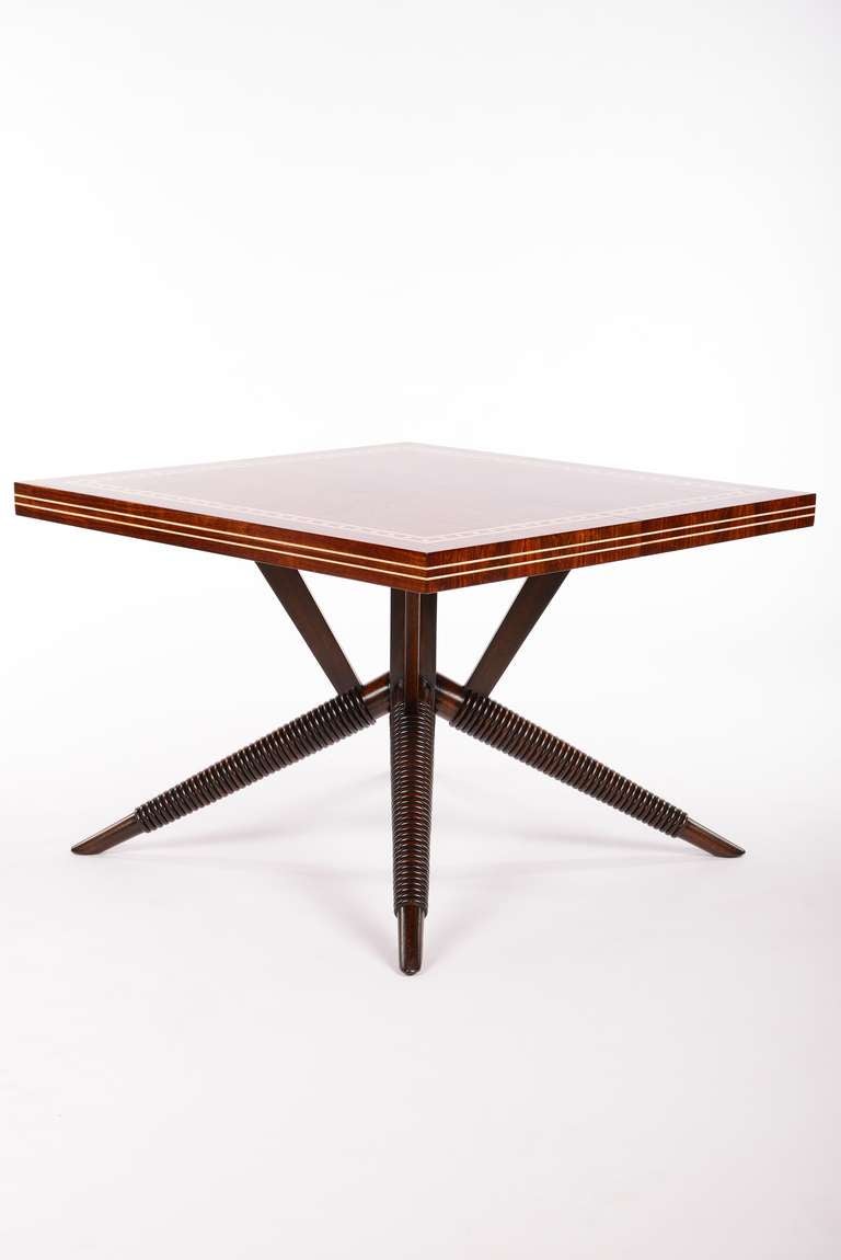 A stunning rosewood dining table with an inlay border of bone dots banded by lines on the top and two lines along the sides of the top. The architectural spider base has a ribbed detail on the bottom legs. The dimensions given below are for the