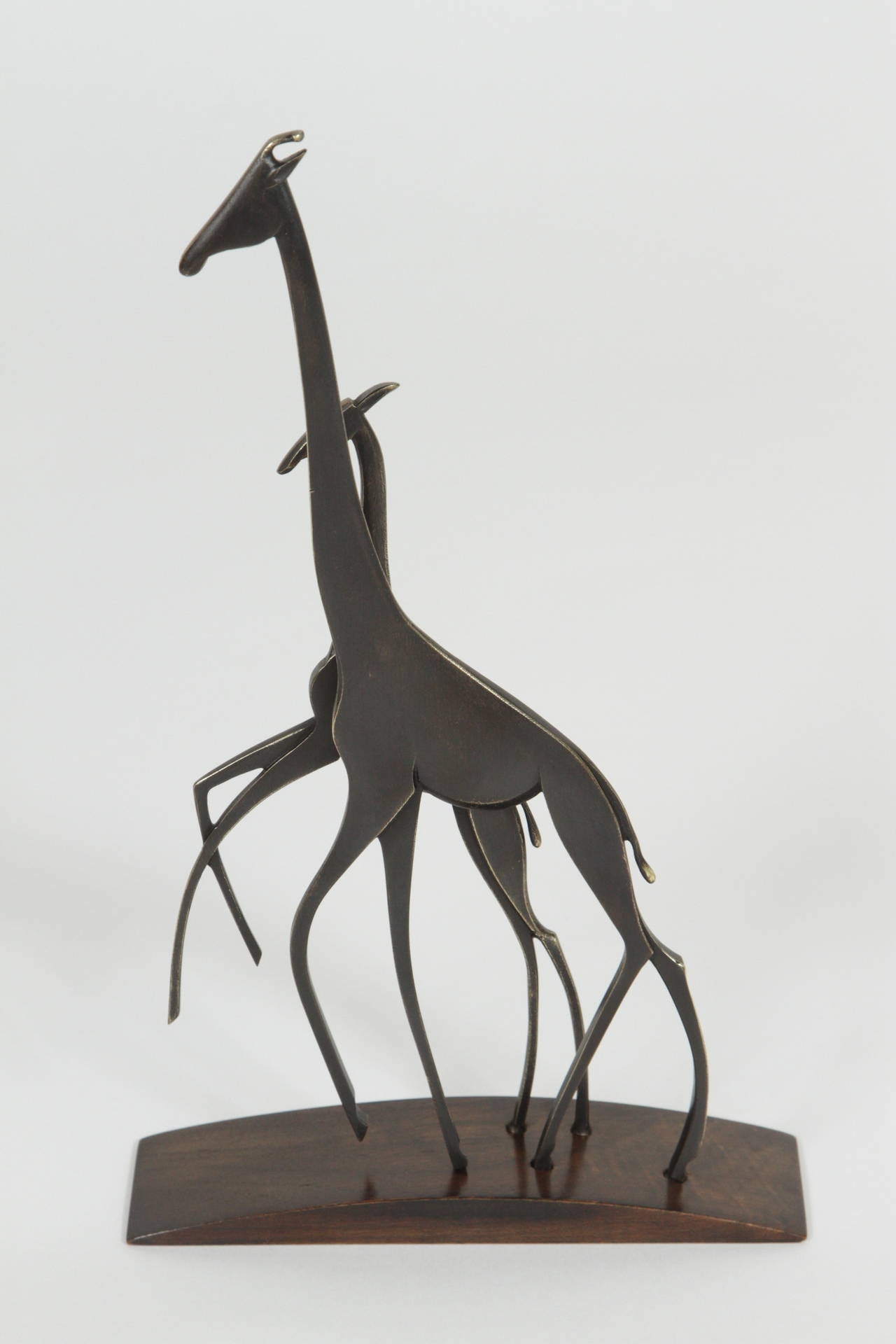 Lovely example of a stylized realization of Europe's fascination with exotic animals, by Franz Hagenauer (1906 - 1986), a sculptor and artisan from Vienna.  Sculpture is an elegant rendition of a mother giraffe with her young, composed of richly