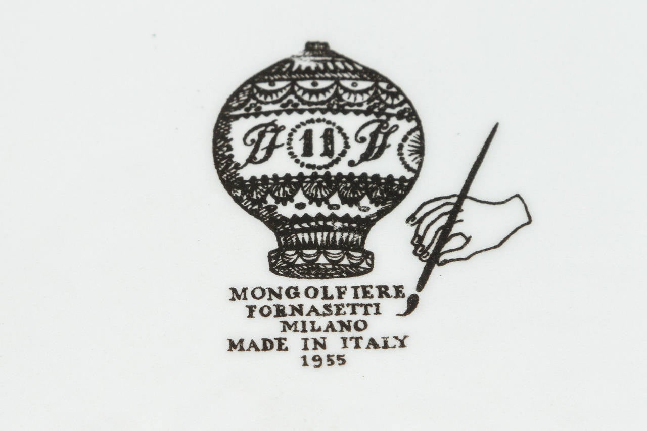 Charming Fornasetti plate numbered 11 from the series Mongofiere done in 1955. This one features a trapeze artist bravely suspended by the hot air balloon 