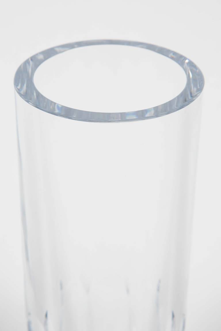A lovely tall cut crystal vase by Cartier featuring simple faceted cuts to the weighted base. Acid etched with their logo on the underside of the vase.