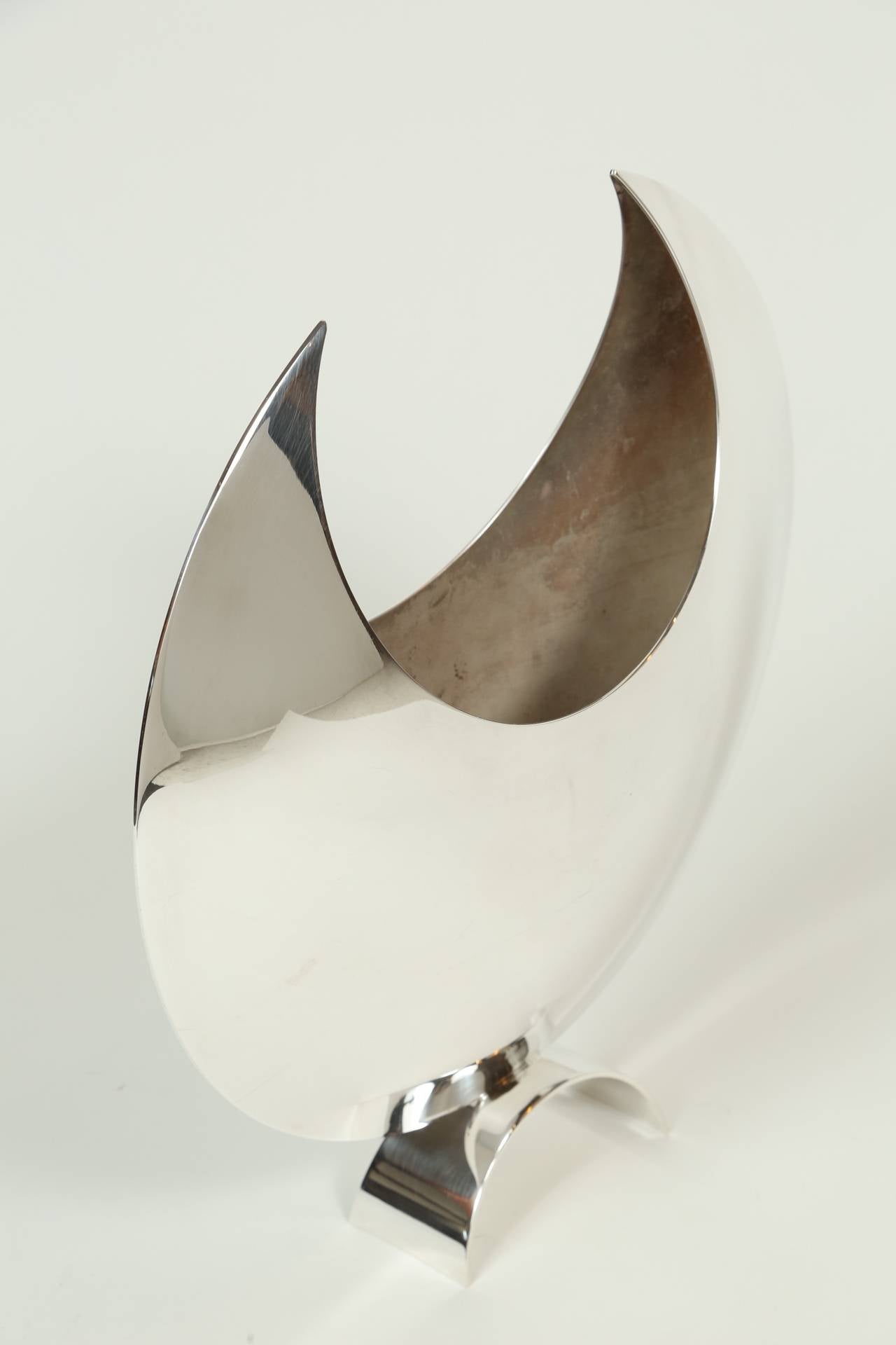 An elegant silver plate crescent moon shaped vase on an arched foot.