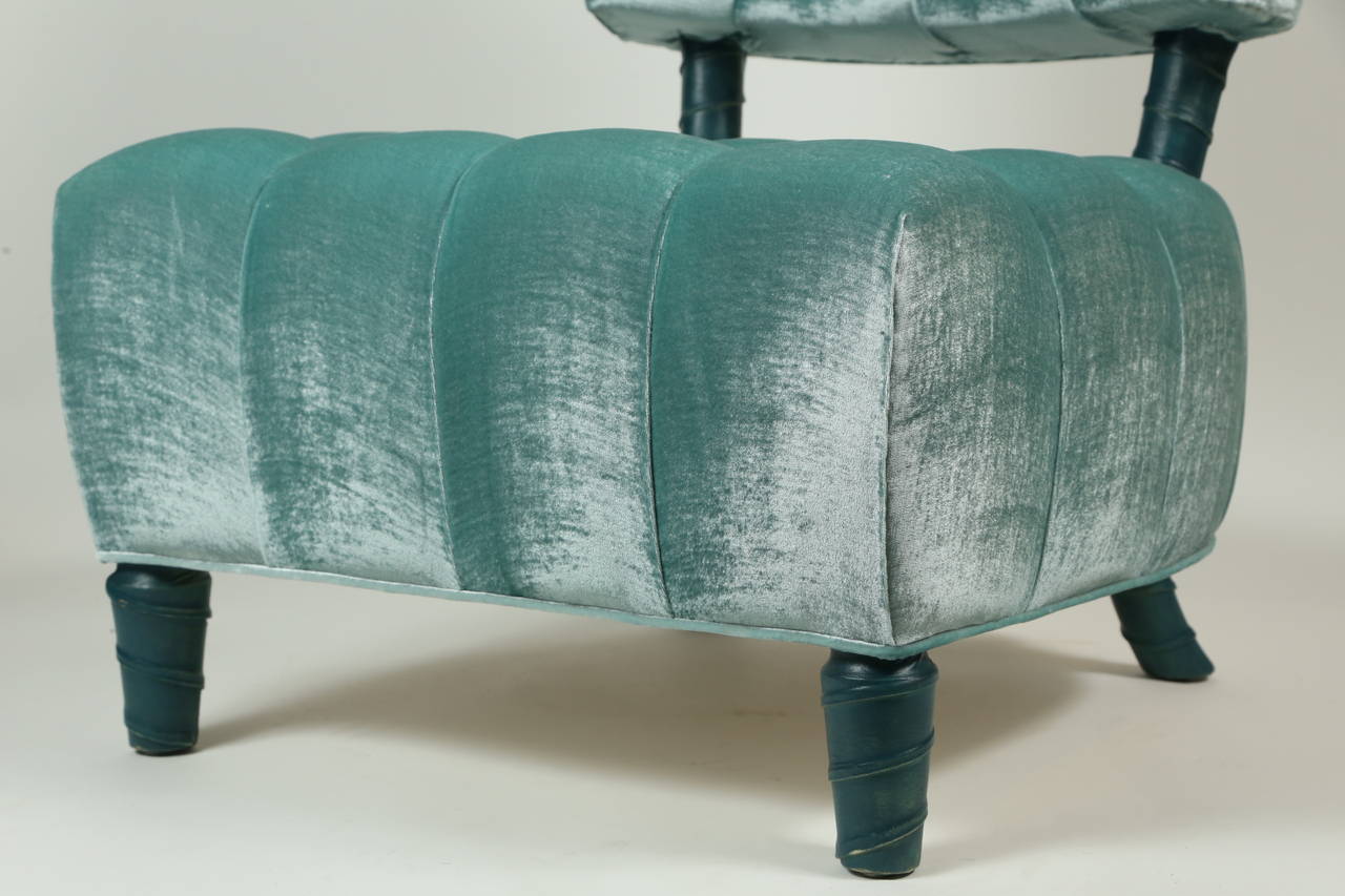 A beautiful biscuit tufted slipper chair by William Haines, upholstered in pale teal silk velvet. The unicorn legs and back of the seat are unusual, in that they are done in a dark teal parchment, rather than Haines' more usual leathers such as