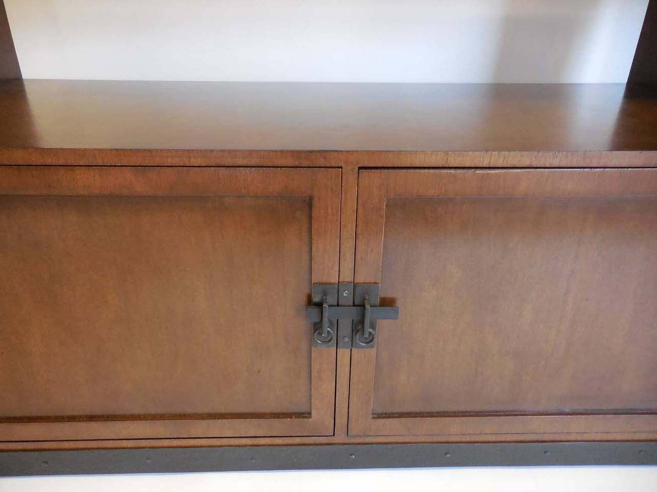 This is a pair of walnut bookshelves made to be either separate or together. Below the shelves is a cabinet with iron closures and kick plate. Upper shelves are fixed. Each entire bookshelf measures: 50 x 20 x 87 H, cabinet is 20 inches high. Sold