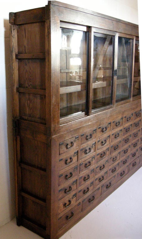 Rare 19th century apothecary chest in perfect condition. It consists of two pieces with 50 small apothecary drawers, ten larger drawers, eight sliding glass doors on top and two sliding doors on bottom piece. Everything is in working condition,