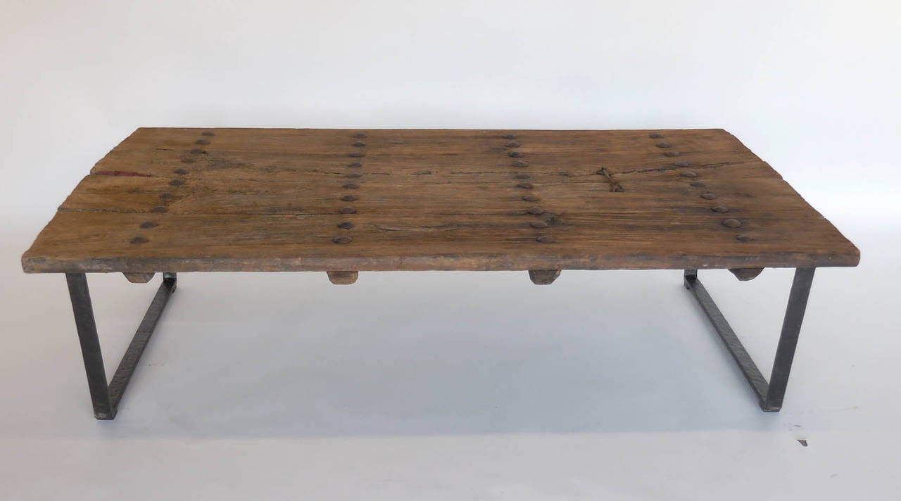 18th century elm doors with old nails from japan upon contemporary hand-forged iron base. Good weathered grey-light brown natural faded finish. Handsome table, smooth and beautifully worn. Sturdy and functional. Original chain hardware door closure