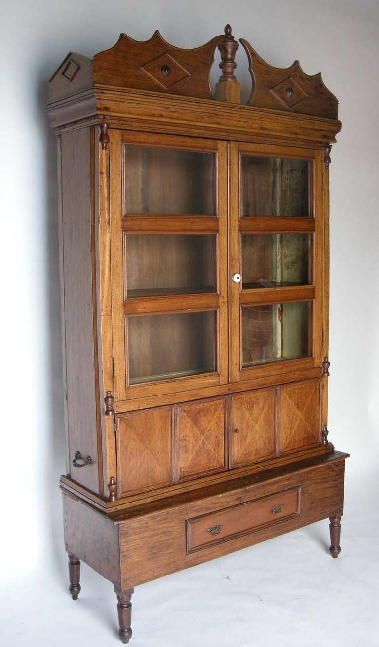 19th c. folk art Chippendale! 
Unusual tall cedro wood and glass front cabinet with three shelves behind glass. Bi fold lower cabinet with two shelves and  drawer below. Carrying handles on each side. Depth of top cabinet is 15