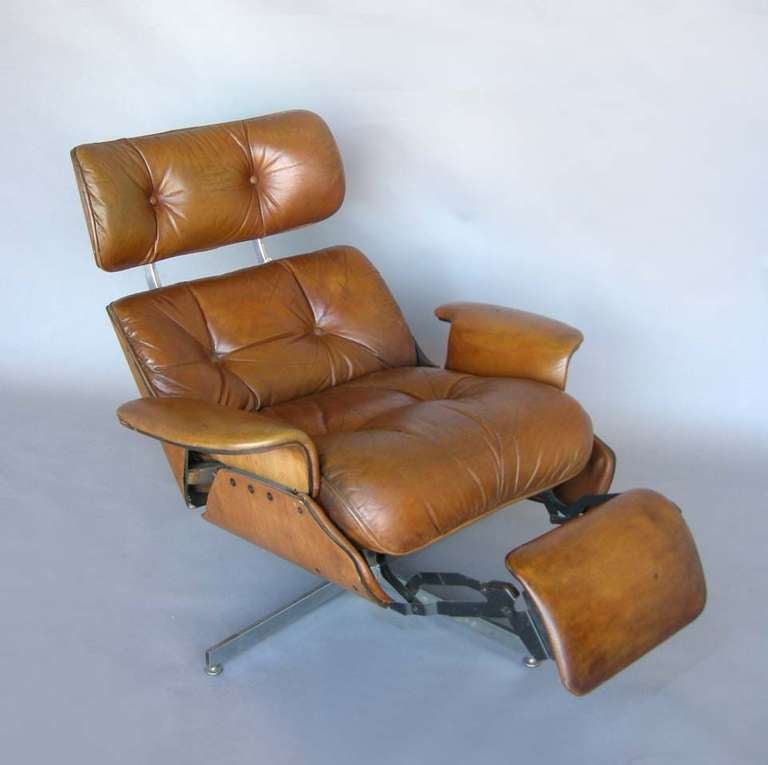 Leather Eames style recliner made by Plycraft with attached foot rest which pops out when chair reclines. In good working condition. Leather has been reconditioned but shows signs of wear. Extends from 38