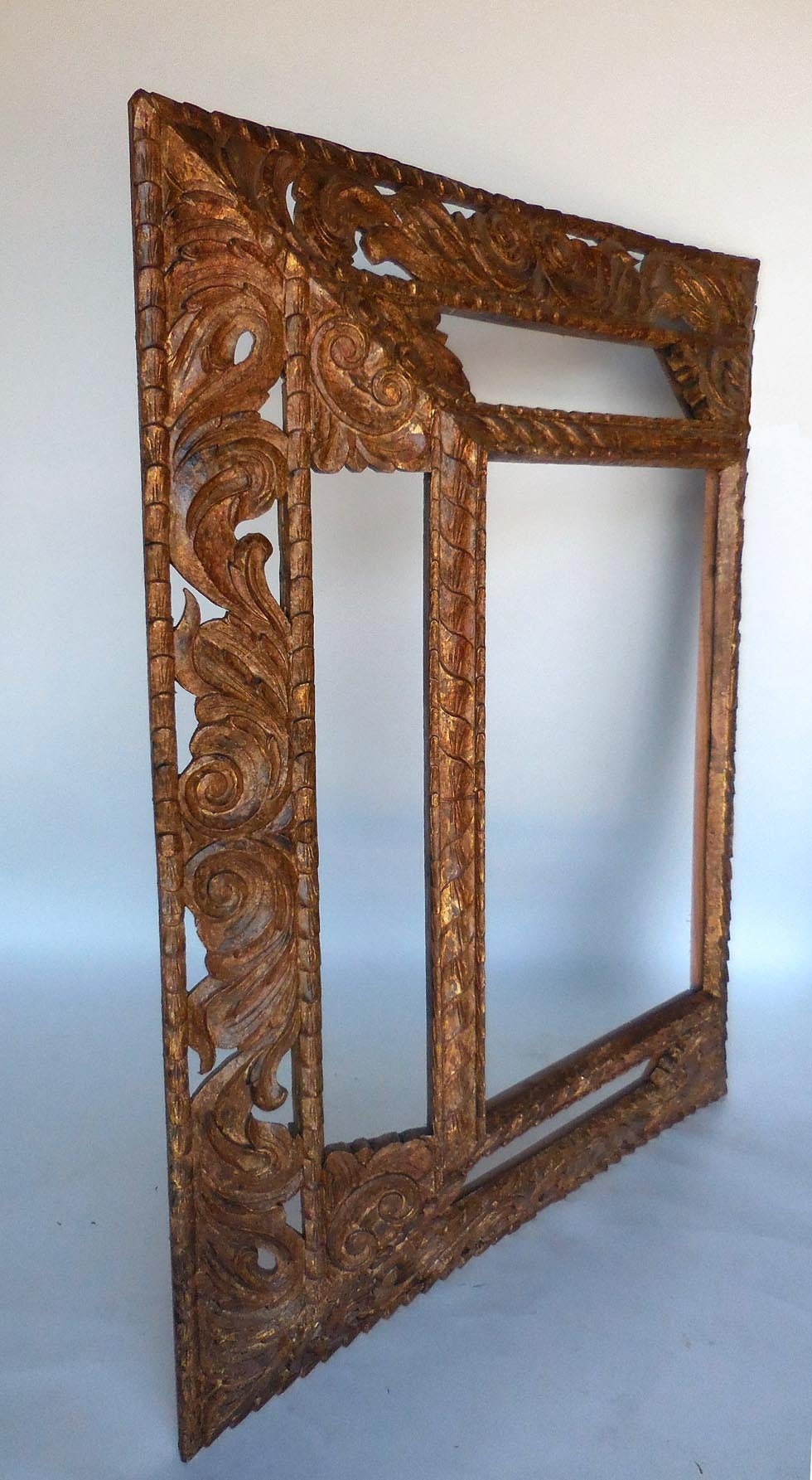 Pair of hand-carved and hand finished large scale mirrors. Five panels. Beautiful and elegant hand-carved hardwood. Lovely warm gold finish. Pair available but priced and sold separately. Price includes clear mirror.