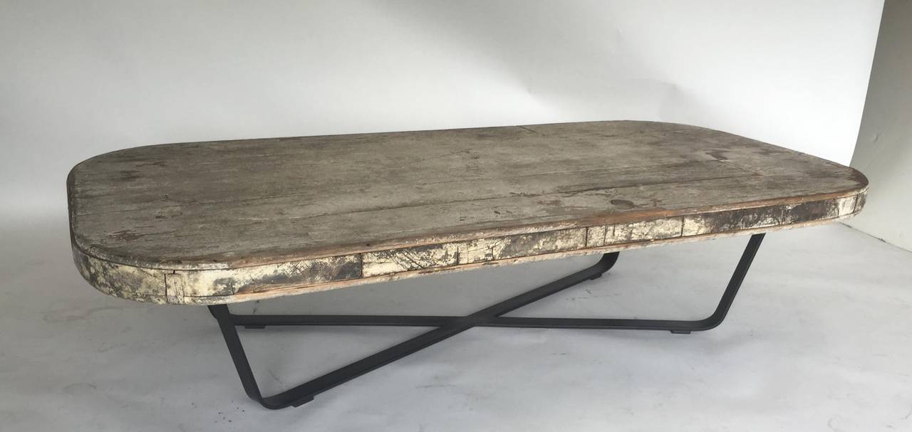 19th century painted tabletop (original paint), 3 1'2" thick, atop hand-forged iron base. Great weathered patina, but contemporary profile.