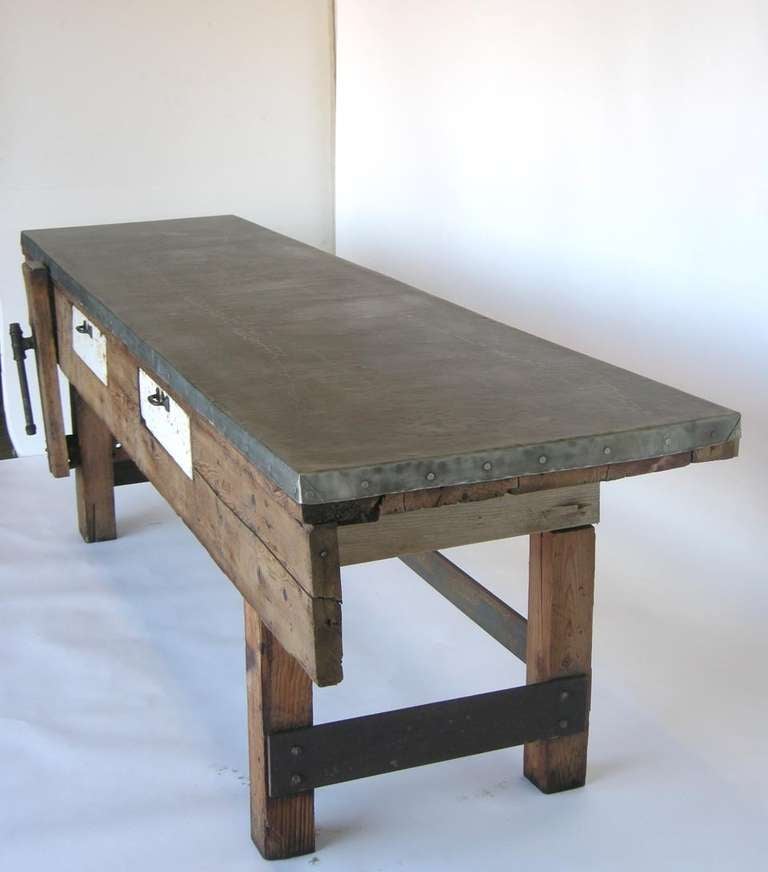 1950s Harley Davidson work table with newer zinc top and drawer linings and hand forged iron stretchers with large rivets.
Original iron clamp, great old worn patina throughout. Scrubbed pine with some traces of paint and white painted drawers.