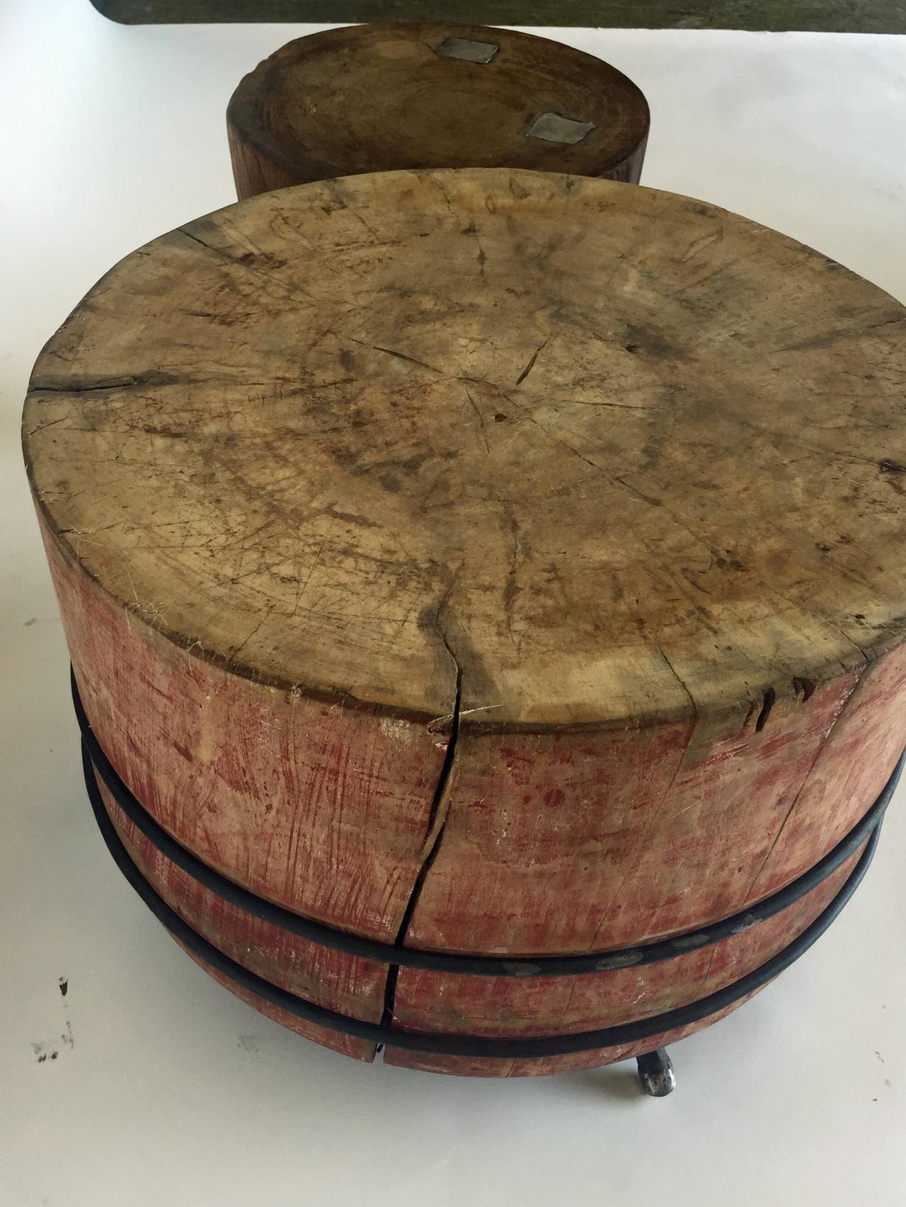 ONLY LARGER ONE ON THE LEFT AVAILABLE!
19th century chopping blocks with tripod hand-forged iron and pewter legs. 
Old red paint on large table.
Large measures: 23 D x 17 H - sale $2,100
