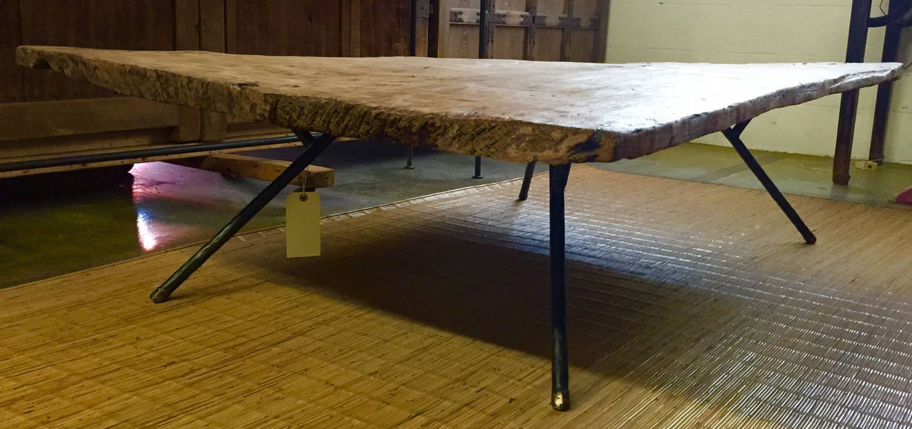 19th century one wide plank top, hand hewn, a bit warped, organic and beautiful. Hand-forged iron and bronze tipped legs. Two old knot holes add to the beauty of this Primitive modern table. Nice patina. Dos Gallos Studio piece.