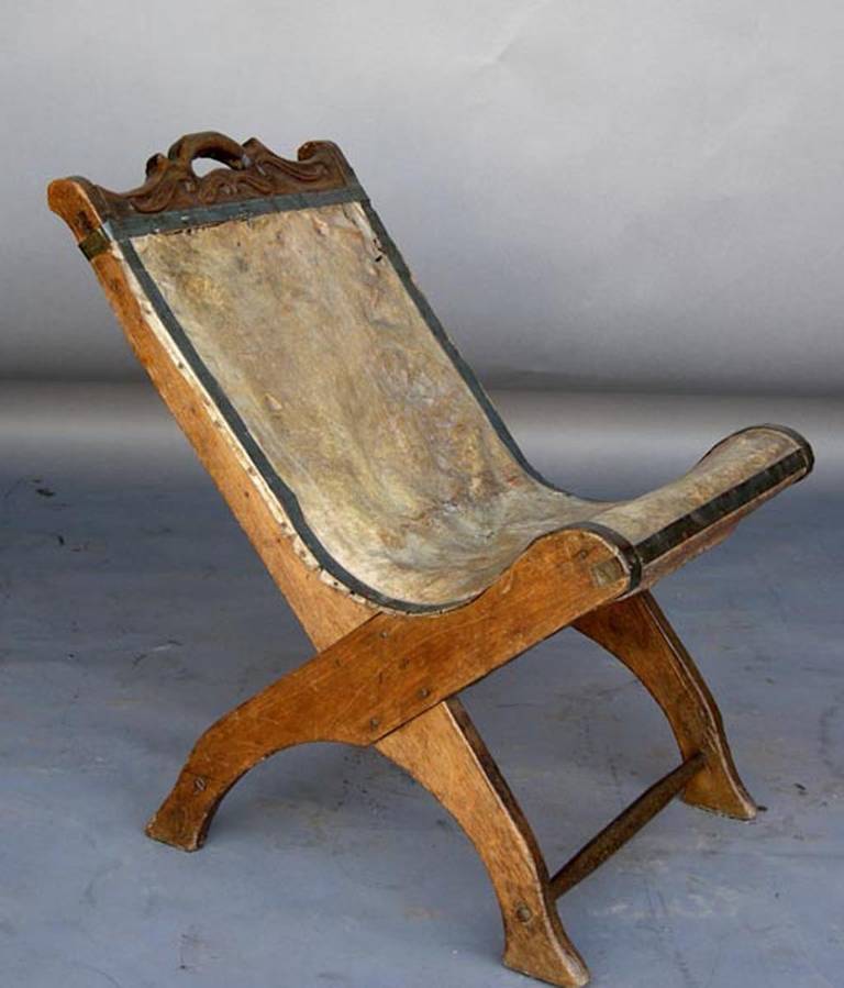 Sweet leather and wood rustic sling chair(butaca) from Guatemala.
This is an adult chair but it is small-scale and works as a small pull up chair for medium size adults or a child's chair. It is all original, including the leather, the metal