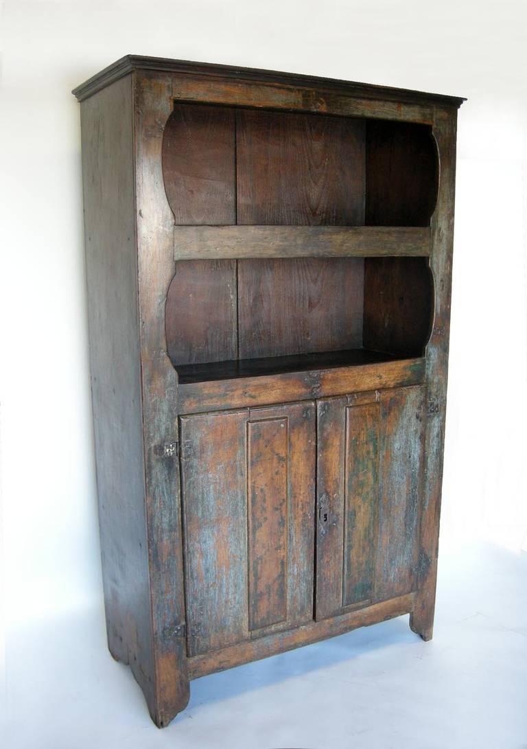 19th century Guatemalan cabinet with traces of old paint. Open shelves on top and closed cabinet with shelves on bottom. Original hardware and key. One wide board on each side.