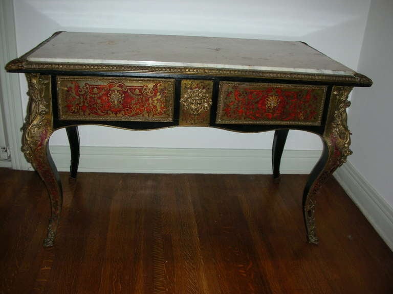 19th century French Boulle work desk with cabriole leg and marble top. Black lacquer finish with brass Boulle work and red faux tortoise inlay.  Brass ormolu mounts at corners and feet.  Two drawers and original marble top. Previously priced at
