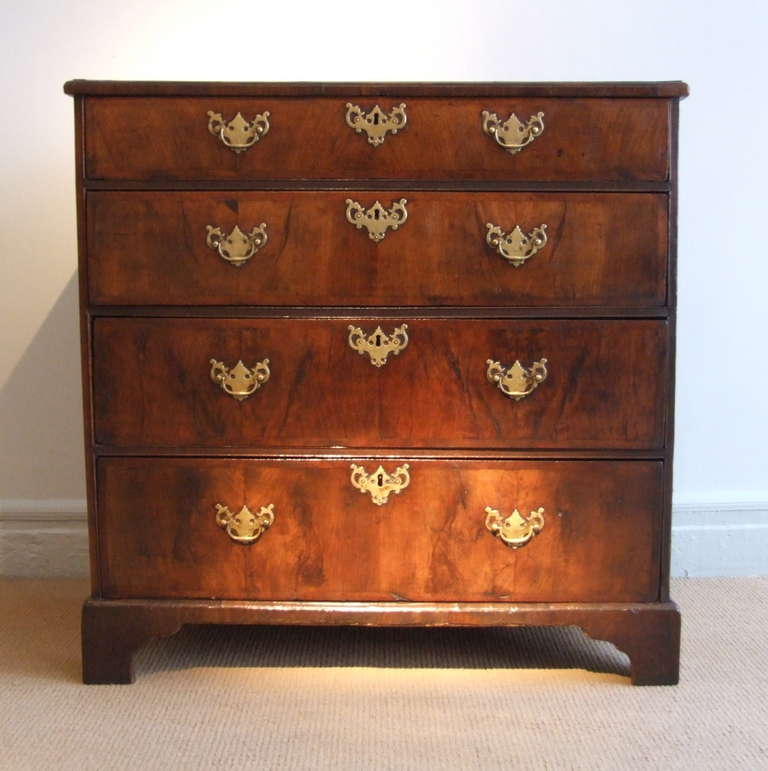 Very fine early 18th Century East Anglian (England) walnut and oak chest of drawers having an excellent patina, the top with front to back book matched veneers with a herring bone stringing and cross banded and molded edge, over four graduated