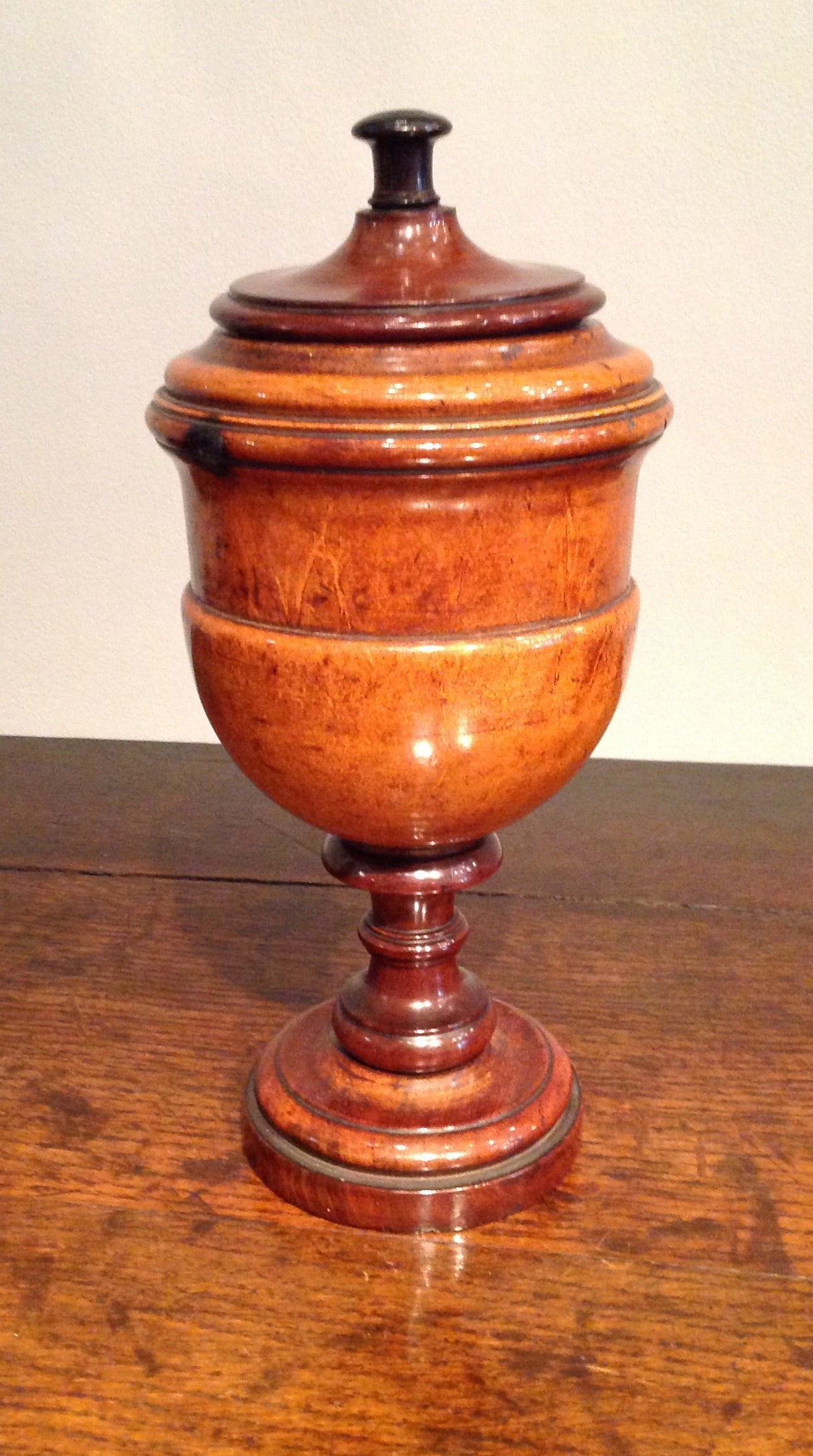 Finely turned English lignum vitae cup and cover the ring turned lid with turned handle, the cup with deeply and crisply turned rings on stepped base. Impressive scale and superb color. A wonderful piece of treen, circa 1880.