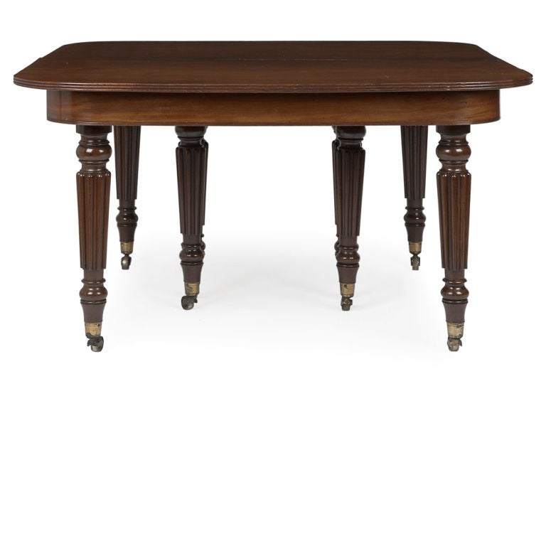 William IV Mahogany Dining Table,<br />
attributed to Gillows, circa 1830, in two parts, the top with rounded reeded corners, raised on circular tapering reeded legs ending in gilt-brass casters, with two leaves (each 19 inches wide).  The whole