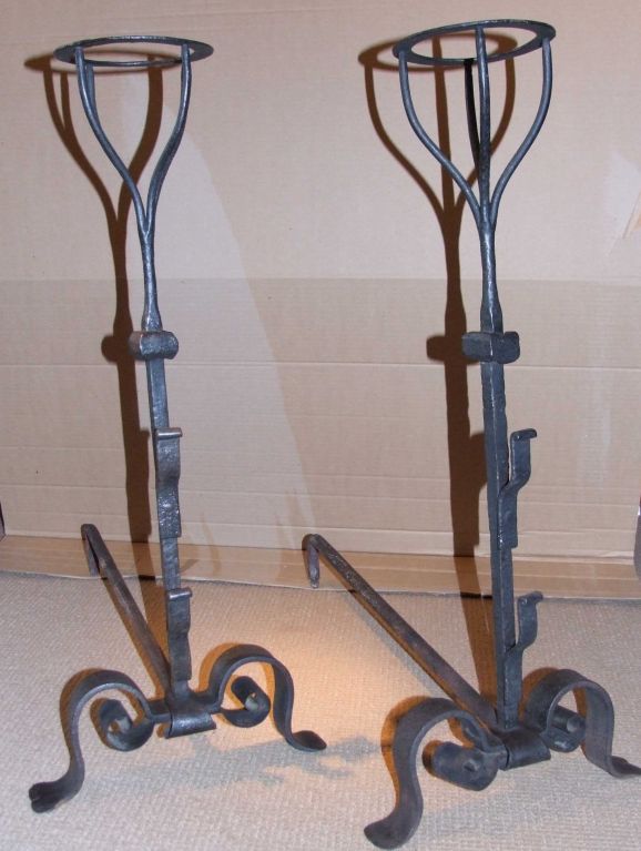 Fine pair of 18th century blacksmith made basket top andirons, the square shaft with center collar and two spit supports, standing on scrolled legs ending in flared feet, the whole having very bold graphic design.