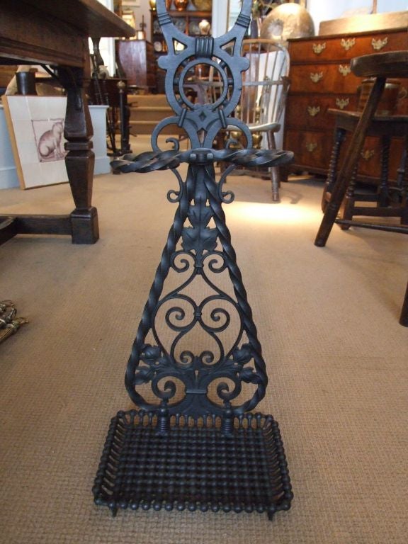 A cast iron umbrella stand by noted maker Bradley and Hubbard, having elaborate scrollwork decoration, twist holder and carrying handle, with wonderful beaded base pan.