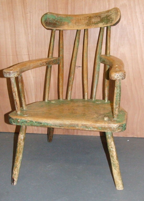 Unusual early 19th Century Irish comb back Windsor armchair, with crude fan back, zig zag spindles, plank seat and spoke shaved legs in wonderful traces of green, brown and yellow paint.  Irish Windsors are scarce, especially ones not in pine.  This