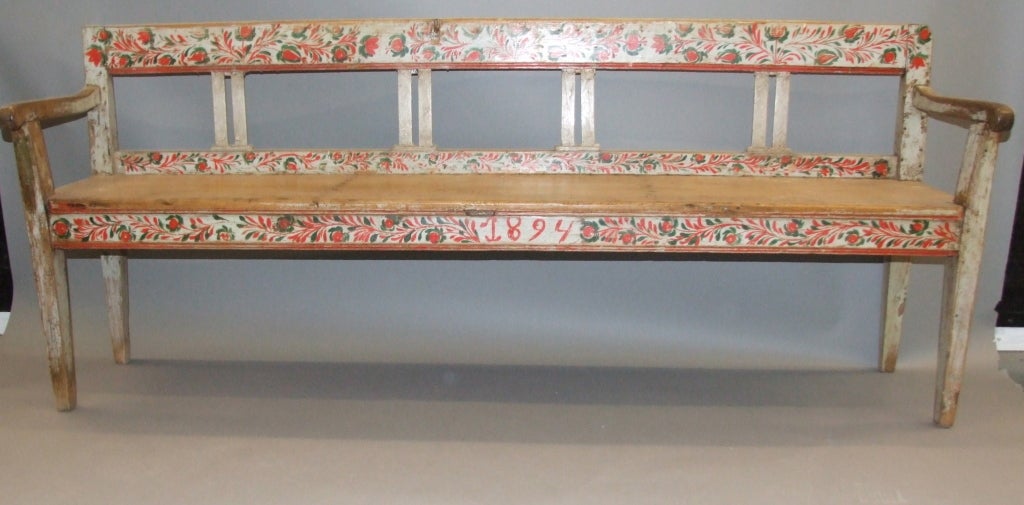 Charming late 19th Century Swedish folk painted long bench, the molded back with rosemaling decorated horizontal rails divided by simple pilaster form uprights, the two plank seat over front rail also with floral decoration and dated 