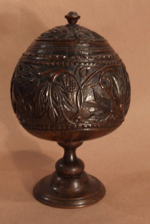 Finely carved early 19th century (or older) English coconut urn, the whole with foliate and vine carving, standing on footed base and having good form and color.