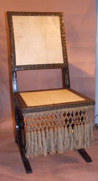 Ebonized and pewter inlaid side chair by Carlo Bugatti, the back and seat upholstered in parchment decorated with hammered copper banding, the turned seat supports wrapped in hammered brass, the seat retaining original fringe.