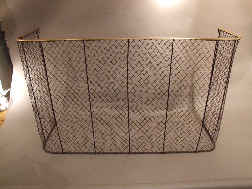 A hard to find English overscale library wrought iron mesh screen for a fireplace having decorative brass rail to top edge.
We keep a number of fire screens and nursery guards in stock at all time.  If the size of this one doesn't work, check our
