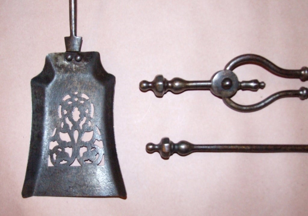 Set of English patinated steel fire tools, having hexagonal nipple handles over simple shafts, the shaped shovel with pierced foliate decoration.