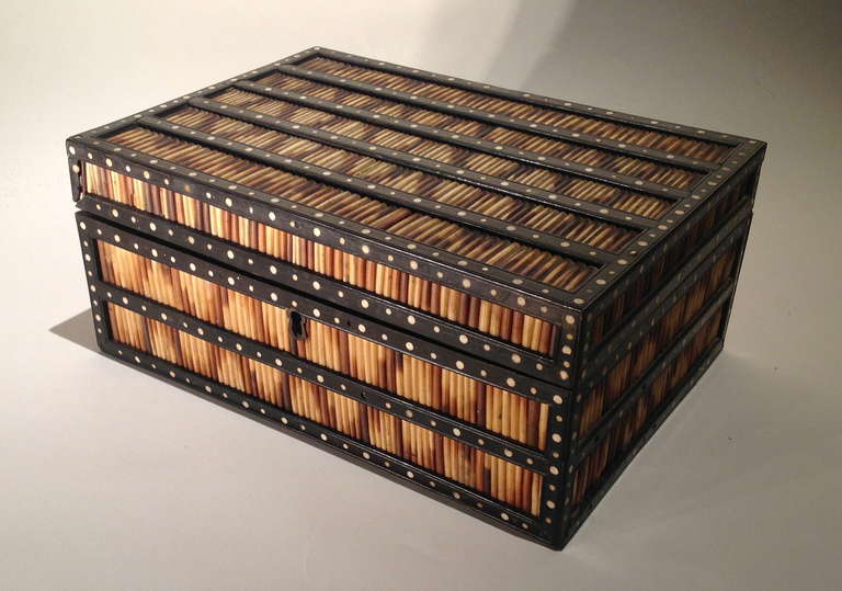 Good mid-19th century Indian box constructed of rows of porcupine quills in a bone inlaid ebony framework, the fitted interior with removable tray of nine lidded compartments, the quills arranged in a 