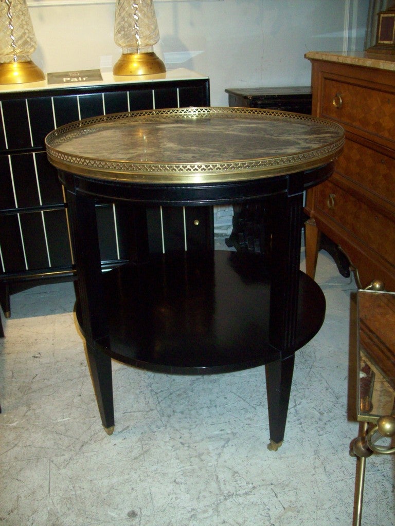 A pair of marble-top two-tiered bouillote tables on castors