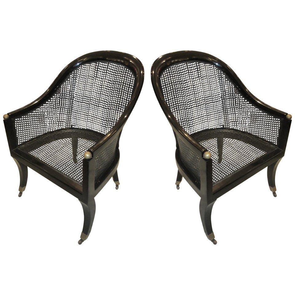 A Pair Of Lacquered And Caned Tub Chairs On Brass Castors