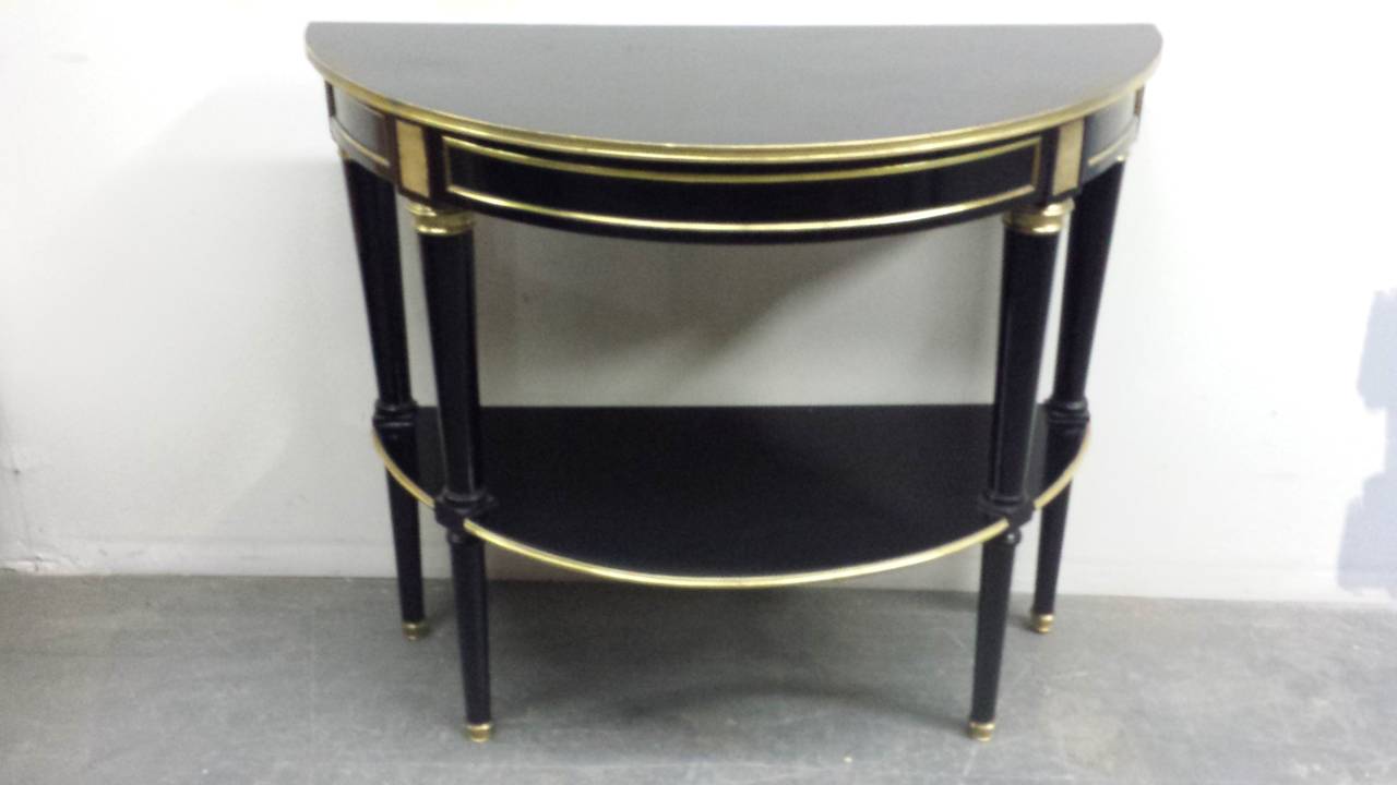 A pair of Directoire style, bronze-mounted demilune consoles on tapered legs.
