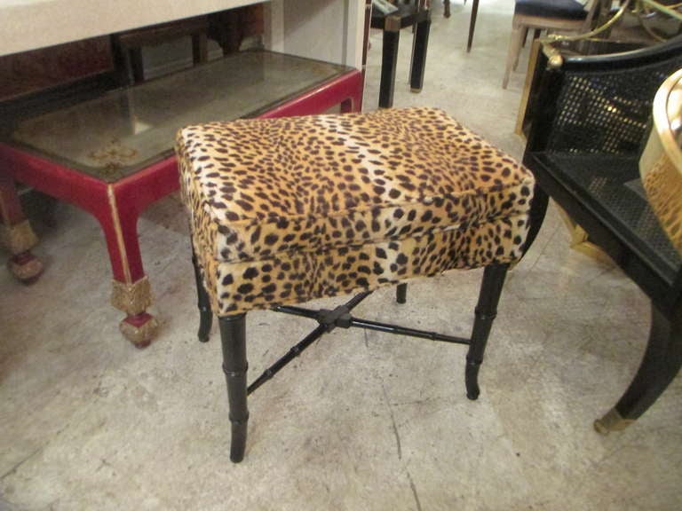 A pair of faux bamboo benches upholstered in leopard print.