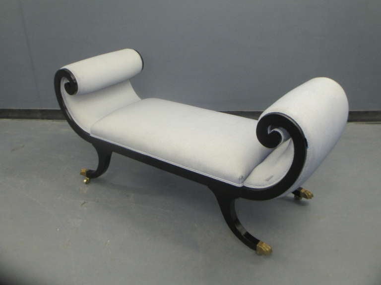 Regency Style lacquered sleigh bench on brass castors.
