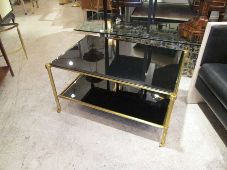 A Pair of Two-Tiered Smoked Glass and Brass Coffee Table  on Castors