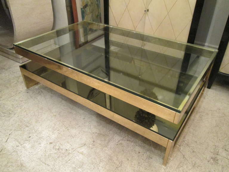 Sculptural cantilevered two-tier brass coffee table, with glass tops.