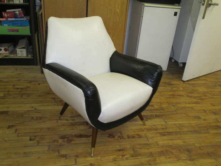 A pair of Mid-Century Modern chairs, upholstered in leather.