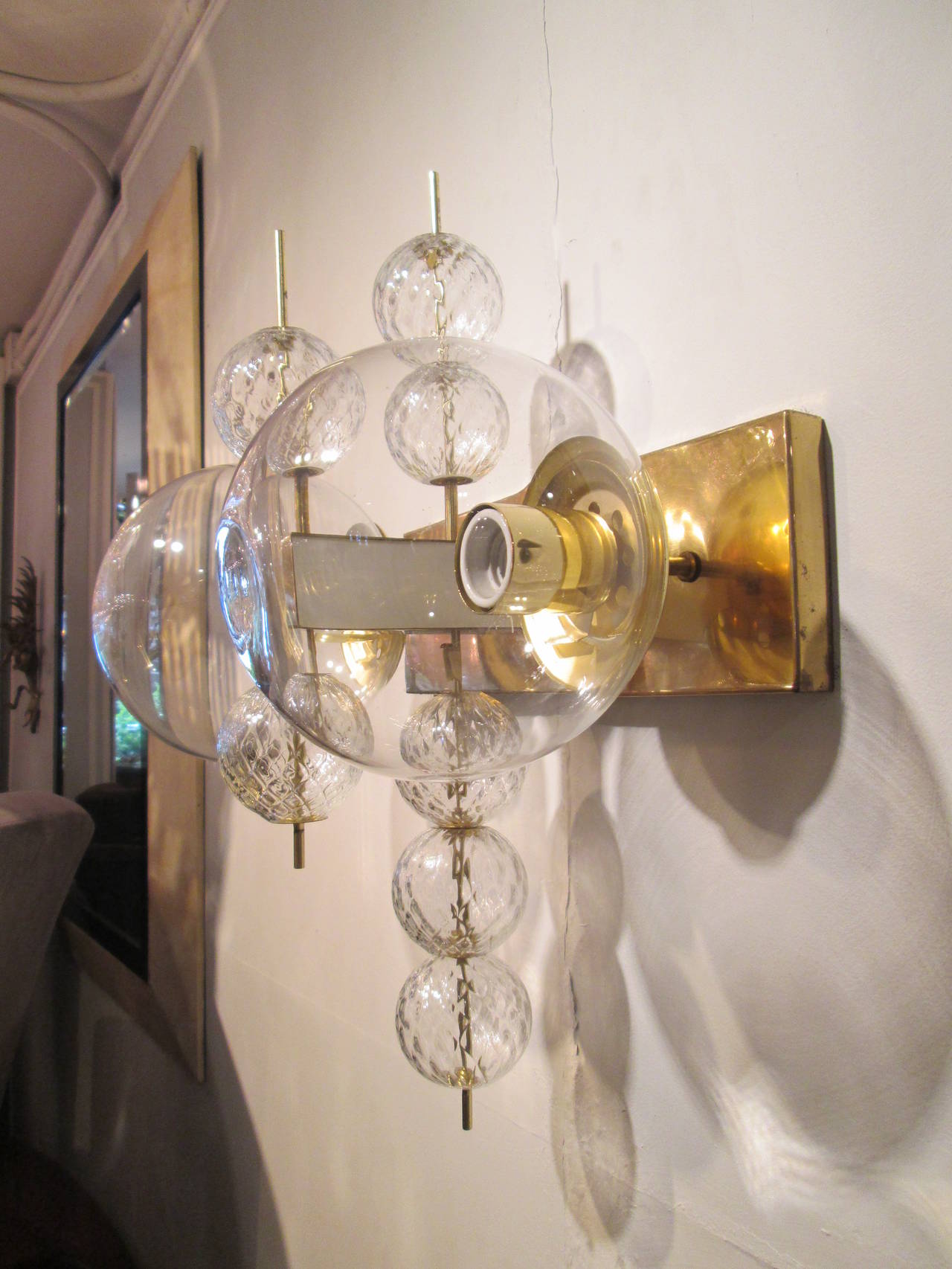 A rare pair of modern brass and glass wall sconces.