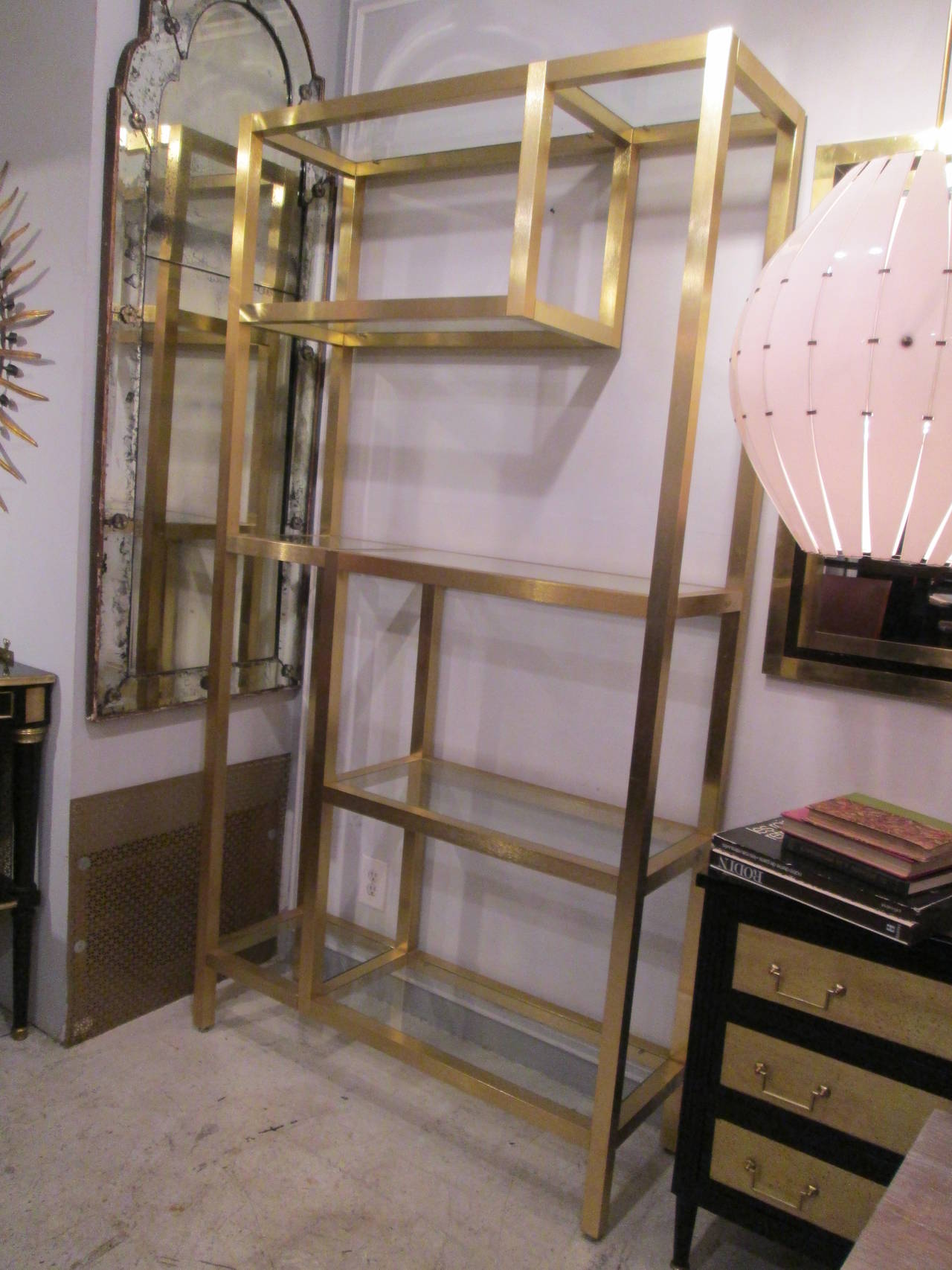 A pair of modern brass etageres or bookcases with five shelves.